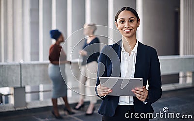 Portable tech keeps me productive wherever I go. Shot of a young businesswoman using a digital tablet against a city Stock Photo