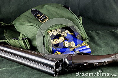 Shotgun with Cartridges and Cartridge Bag on an Outdoor Coat Stock Photo