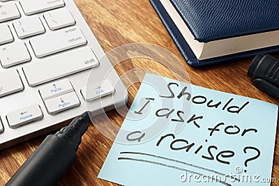 Should I ask for a raise. Office desk with papers. Stock Photo