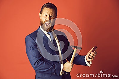 Shouting businessman crushing mobile phone with hammer, overtime, crash test Stock Photo