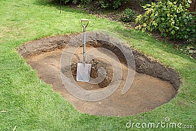 Shovel in hole for pond Stock Photo