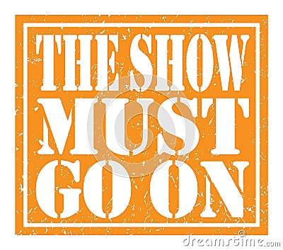 THE SHOW MUST GO ON, text written on orange stamp sign Stock Photo