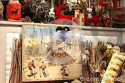 Showcase in a gift shop with Christmas items in the evening. Retro clock with skiers, candle lanterns, pine cones, Christmas Editorial Stock Photo
