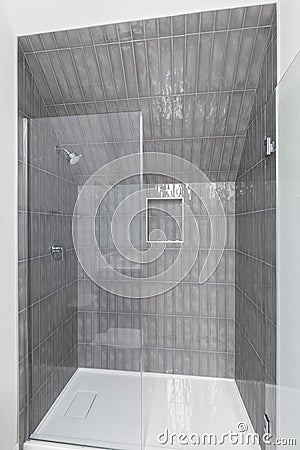 A shower with dark grey subway tiles. Stock Photo