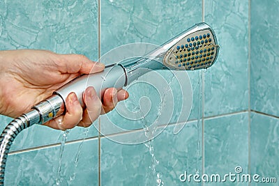 Cracked shower head is leaking and needs to be replaced. Stock Photo