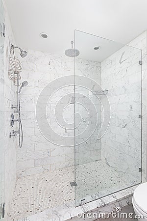 A shower with marble subway tiles and chrome showerhead. Stock Photo