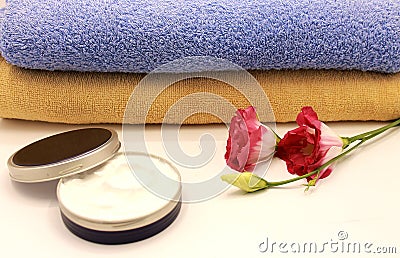Shower towels, face cream and flower Stock Photo