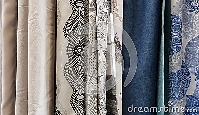 Showing colorful curtain patterns in a store. Large rows of pieces of fabric made of cotton, polyester, tapestry and other Stock Photo