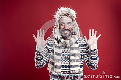 Showing openness. Mature fashion model enjoys cold weather style. Bearded man accessorizing sweater with hat and scarf Stock Photo