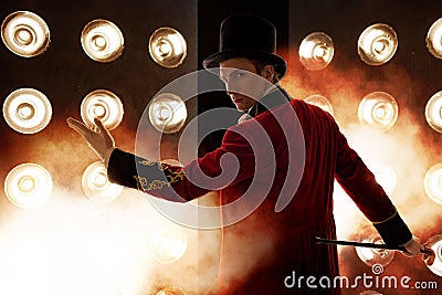 Showman. Young male entertainer, presenter or actor on stage. The guy in the red camisole and the cylinder. Stock Photo