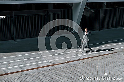 Shows middle finger. Young successful businessman in grey formal wear is outdoors in the city Stock Photo