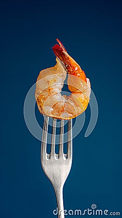 Shrimp on fork on blue Stock Photo