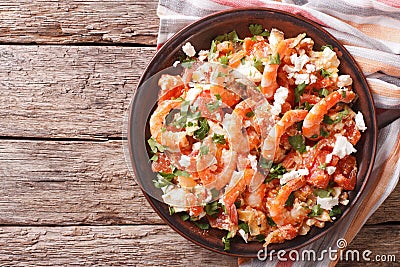 Shrimp saganaki with tomato and feta cheese on a plate. Horizontal top view Stock Photo