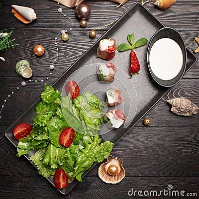 Shrimp and strawberry rolls on a plate and cream in a cup Stock Photo