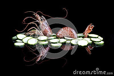 Shrimp and zucchini on a black reflective surface Stock Photo