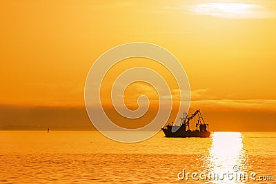 Shrimping boat at sunset on ocean Stock Photo