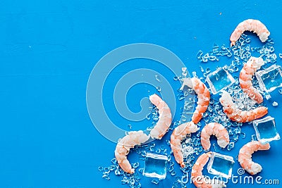 Shrimps - peeled, with ice - on blue table frame copy space Stock Photo