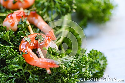 Shrimps prawns in skewer sticks seafood cooked with ketchup sauce herbs and spices on curly parsley background Stock Photo