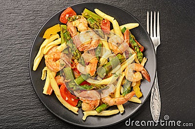 Shrimps prepared with asparagus, tomatoes and paprika. Stock Photo