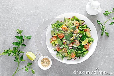 Shrimps salad with green lettuce, cucumbers and avocado, dressed with lime juice, healthy and tasty food, top view Stock Photo