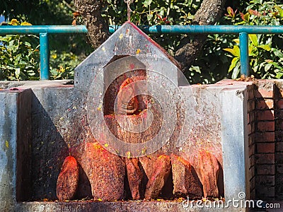 Shrine covered in vermillion to worship Goddess Kali. Red pigment powder on stone, Kali Shrine in Dhulikhel, Nepal Stock Photo