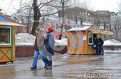 Shrovetide celebration in Moscow. People walk by wooden houses. Editorial Stock Photo