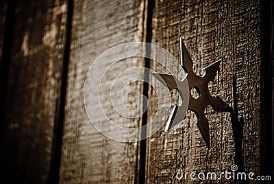 Shuriken star embedded in wood Stock Photo