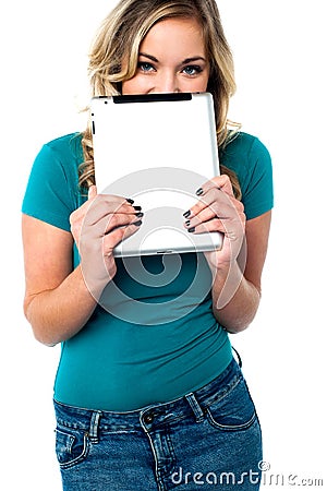 Shy pretty model hiding face with tablet pc Stock Photo