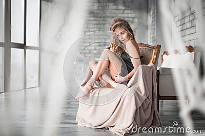 A shy, smiling blonde in a black dress Stock Photo