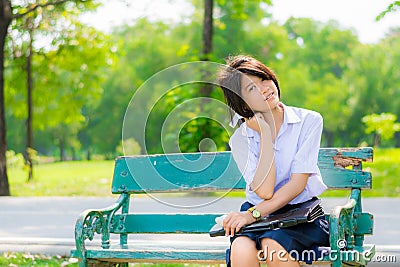 Shy Thai schoolgirl sitting on a bench closeup Stock Photo