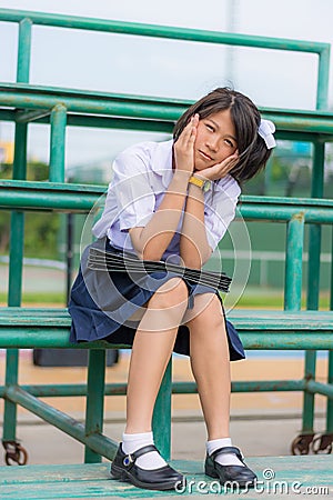 Shy Thai schoolgirl sitting on a stand Stock Photo