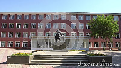 Shymkent state university. Shymkent South Kazakhstan State University M. Auezov frontal view with statue of sultan Suleymenov on a sunny blue sky day stock footage Shymkent state university. Shymkent South Kazakhstan State University M. Auezov frontal view with statue of sultan Suleymenov on a sunny blue sky day stock footage