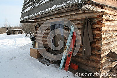Siberian hunting hut in winter with skis at the entrance Stock Photo