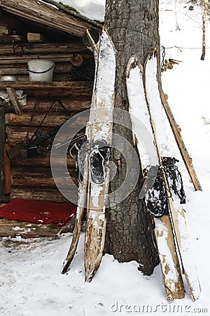 Siberian hunting skis and weapons at the wall of the winter quarters in the taiga Stock Photo