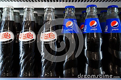 Sibiu, Romania - May, 11 2022: Close up of Pepsi Cola glass bottles in supermarket fridge. Vintage and modern Pepsi Editorial Stock Photo