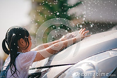 Sibling Asian girls wash their cars and have fun playing indoors on a hot summer day Stock Photo