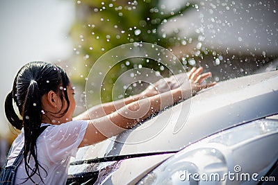 Sibling Asian girls wash their cars and have fun playing indoors on a hot summer day Stock Photo