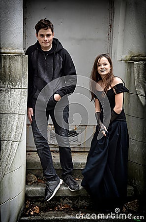 Siblings dressed in black in a spooky surrounding Stock Photo