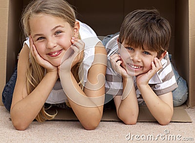 Siblings playing with boxes after moving house Stock Photo
