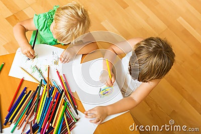 Siblings playing with pencils Stock Photo