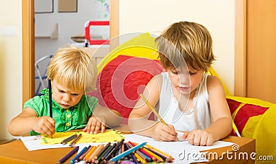 Siblings playing with pencils Stock Photo