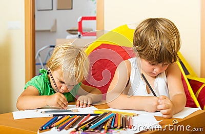 Siblings playing with pencils Stock Photo