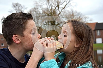Siblings sharing pastry Stock Photo
