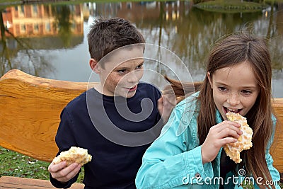 Siblings sharing a piece of pastry Stock Photo