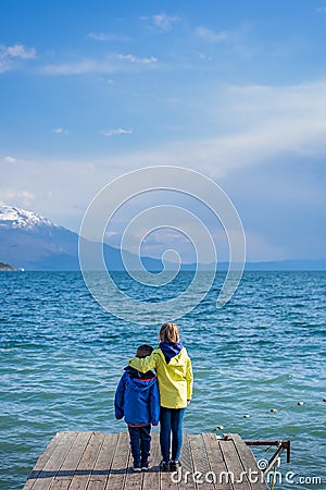 Siblings standing on a wooden pier Stock Photo