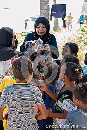 Sibuan, Malaysia - November 26, 2019: Visitors distributing snacks and goods to the Bajau Laut kids in their village Editorial Stock Photo