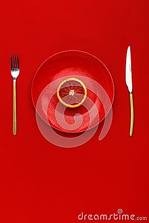 Sicilian orange cut in half on a red plate. Top view. Copy space. Creative concept Stock Photo