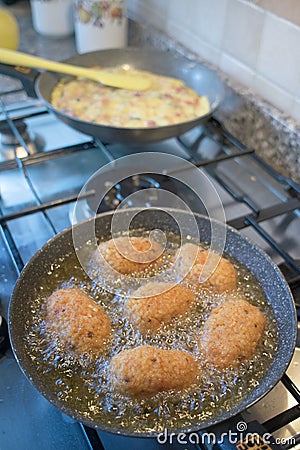 Rice croquettes frying in boiling oil Stock Photo