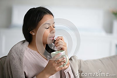 Unhealthy biracial woman feel sick taking pill Stock Photo