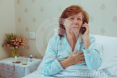 Sick aged woman calling her doctor. Stock Photo